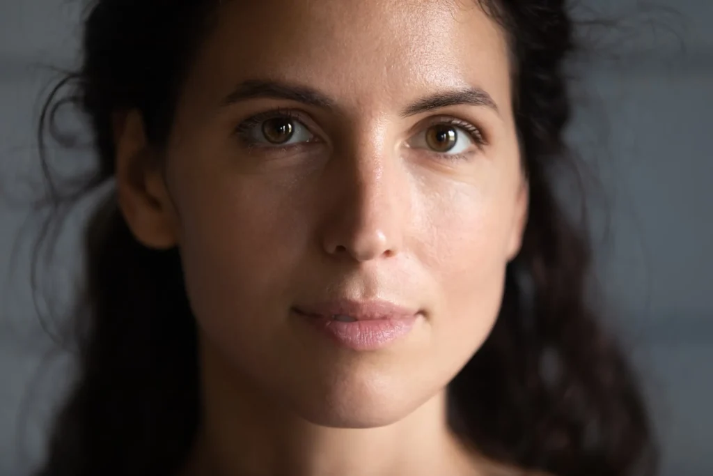 Close-up portrait of a woman with clear skin, used to represent hormonal imbalance treatments and skin health at a medical clinic.